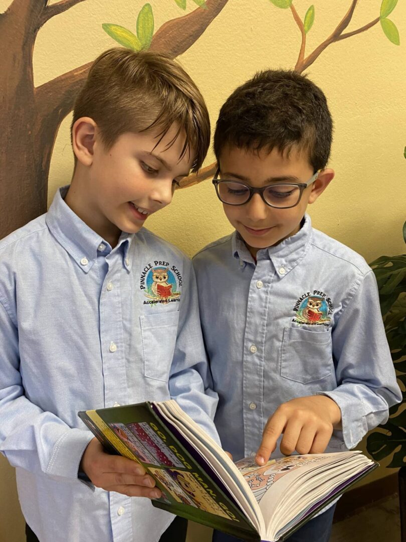 Two boys are reading a book together.