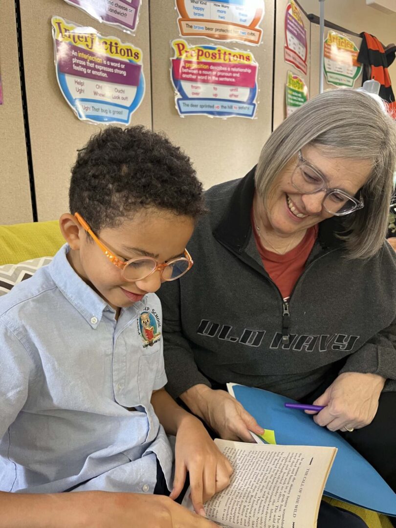 A woman and boy in glasses looking at something.