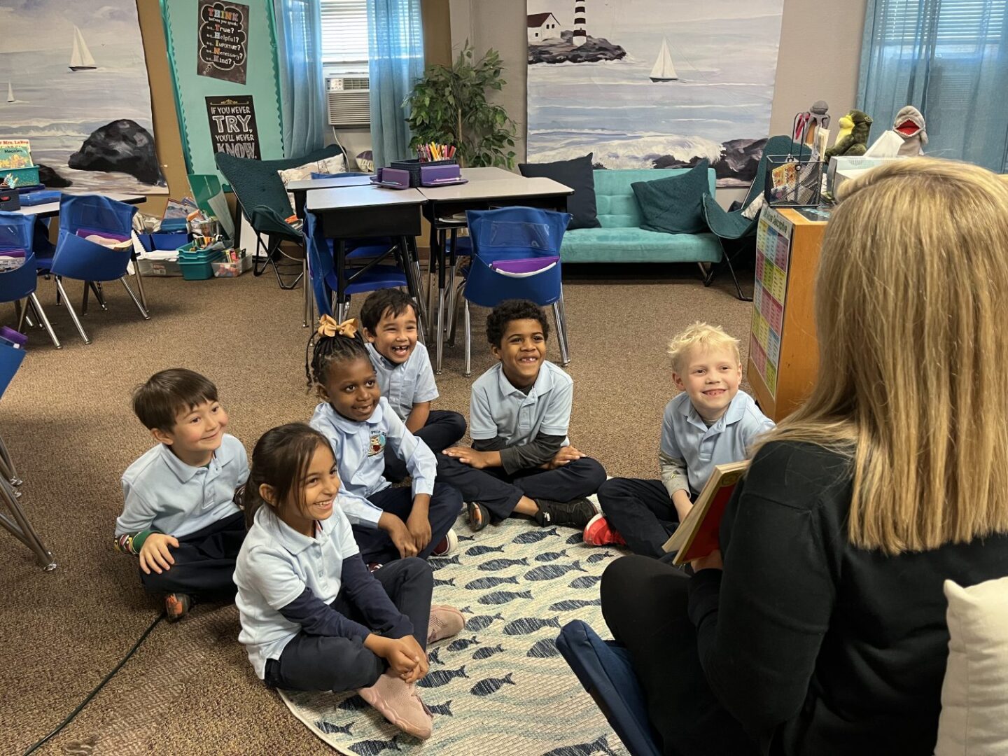 A group of children sitting on the floor in front of a woman.