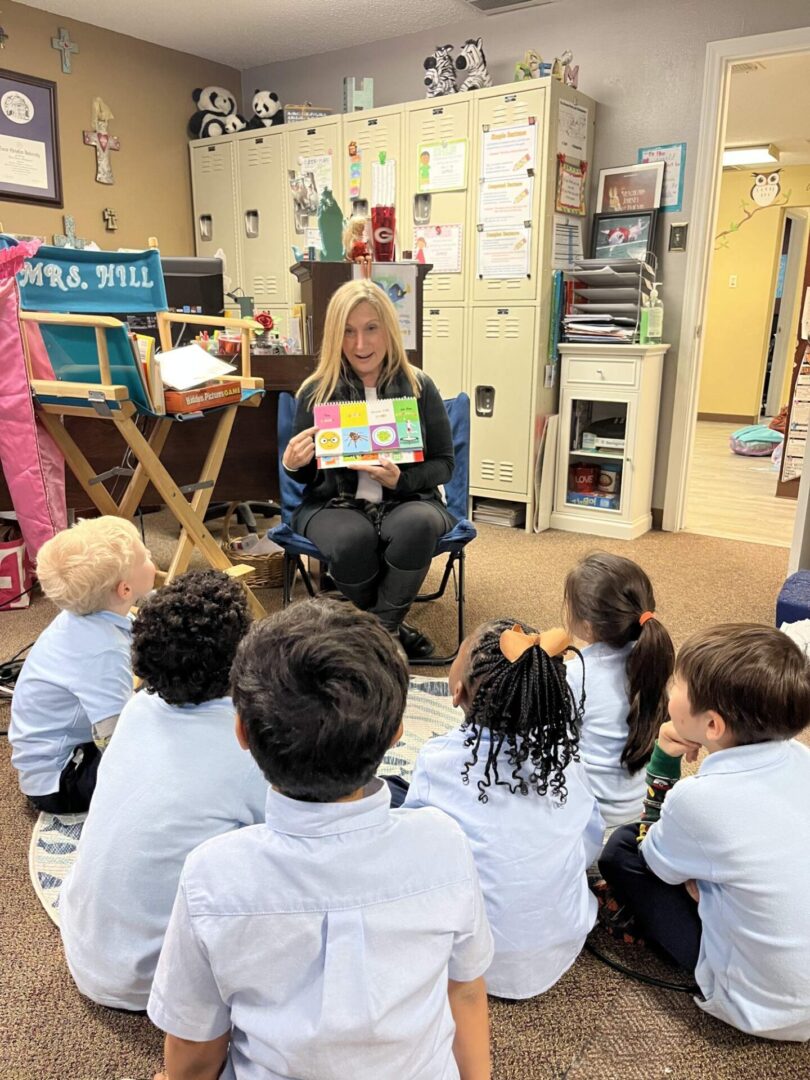 A woman reading to children in the classroom.